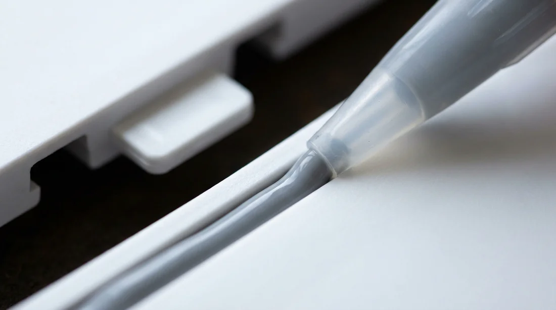 Pose du silicone dans la rainure d'un panneau Dumawall